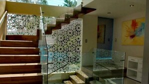 Una escalera moderna con barandillas de vidrio y peldaños de madera.