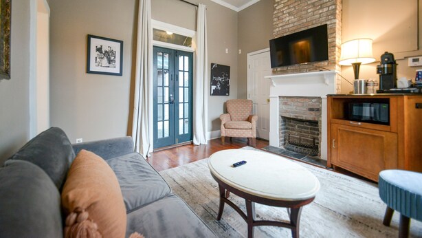 Una sala de estar con sofá, una mesa redonda, chimenea y televisión.