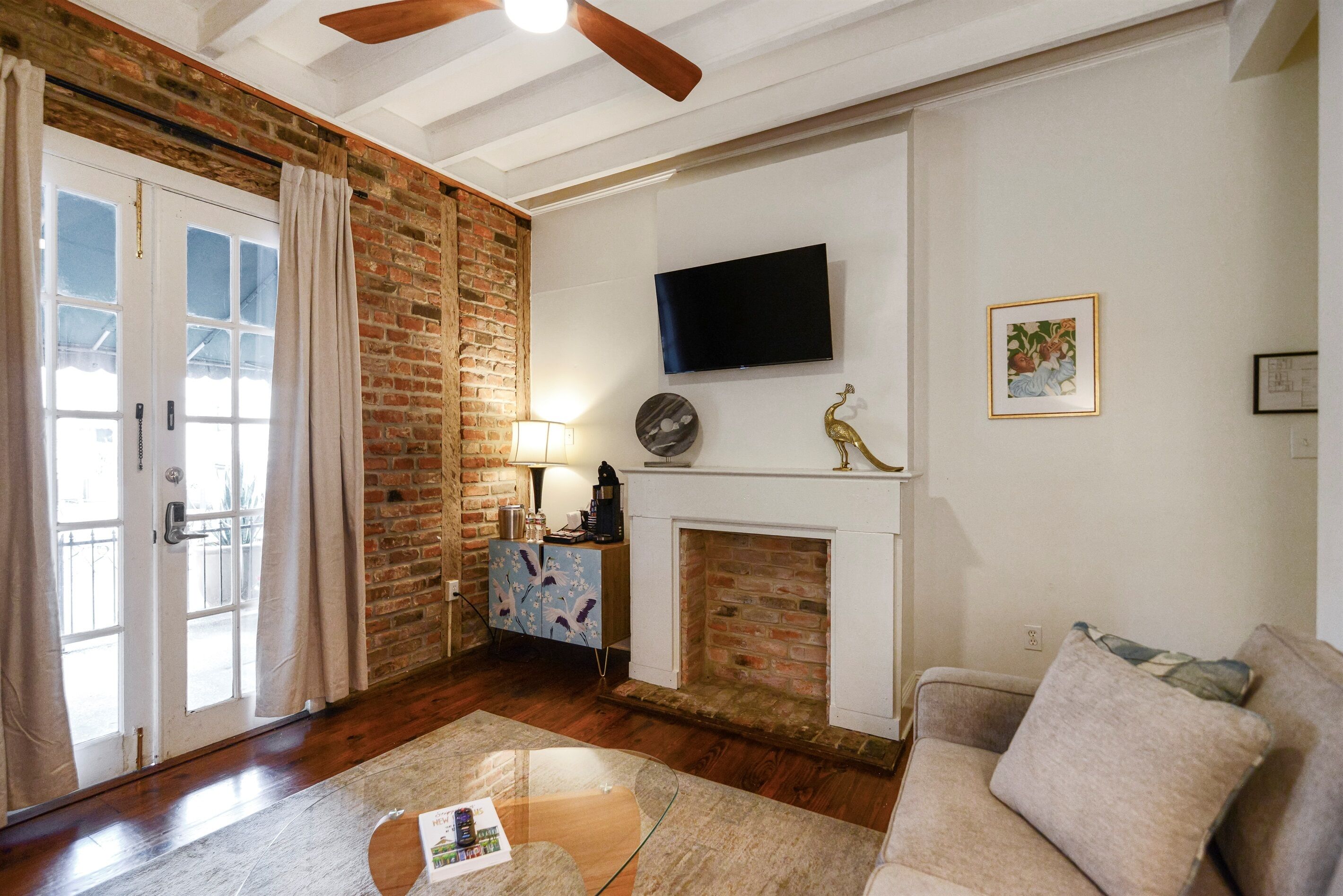 Ein Wohnzimmer mit Kamin, Wandfernseher, Couchtisch und Sofa.