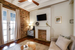 A living room with a fireplace, a television mounted on the wall, a coffee table, and a sofa.