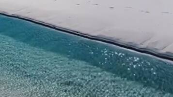 Un cielo azul despejado y mar tranquilo.