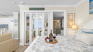 Un dormitorio con cama, una bandeja con vino y uvas, un reloj y un cartel que dice 'Nothing to Do Beach'.