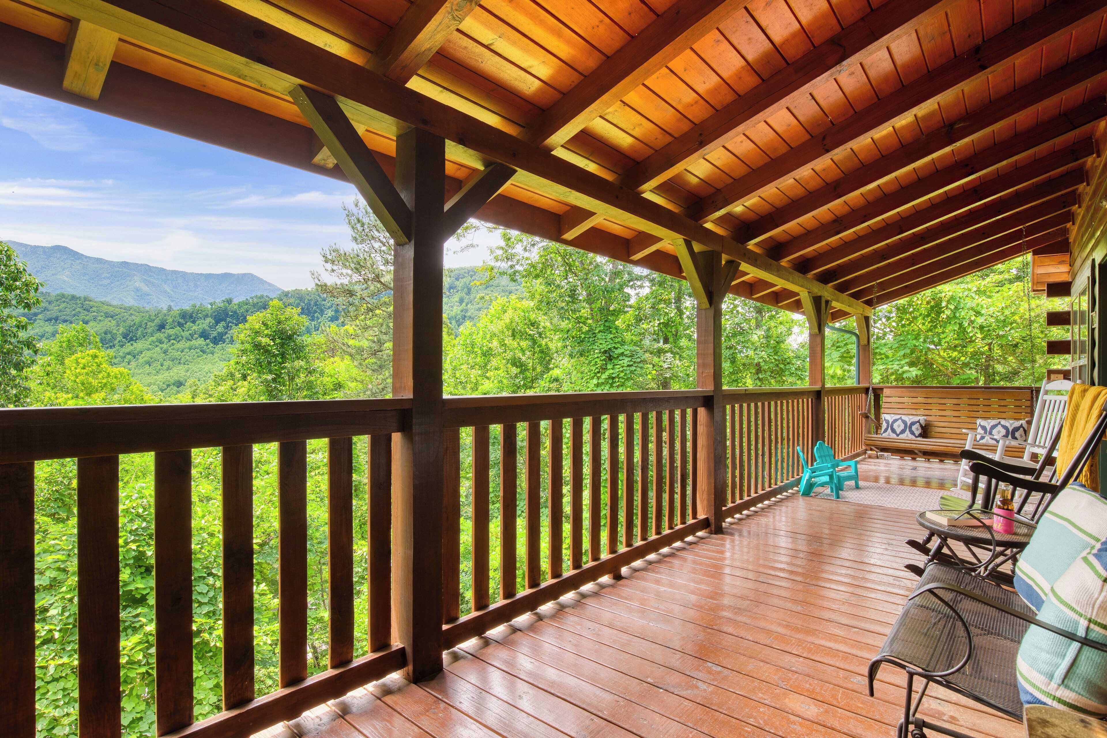 A wooden deck with a view of a forested mountain range.
