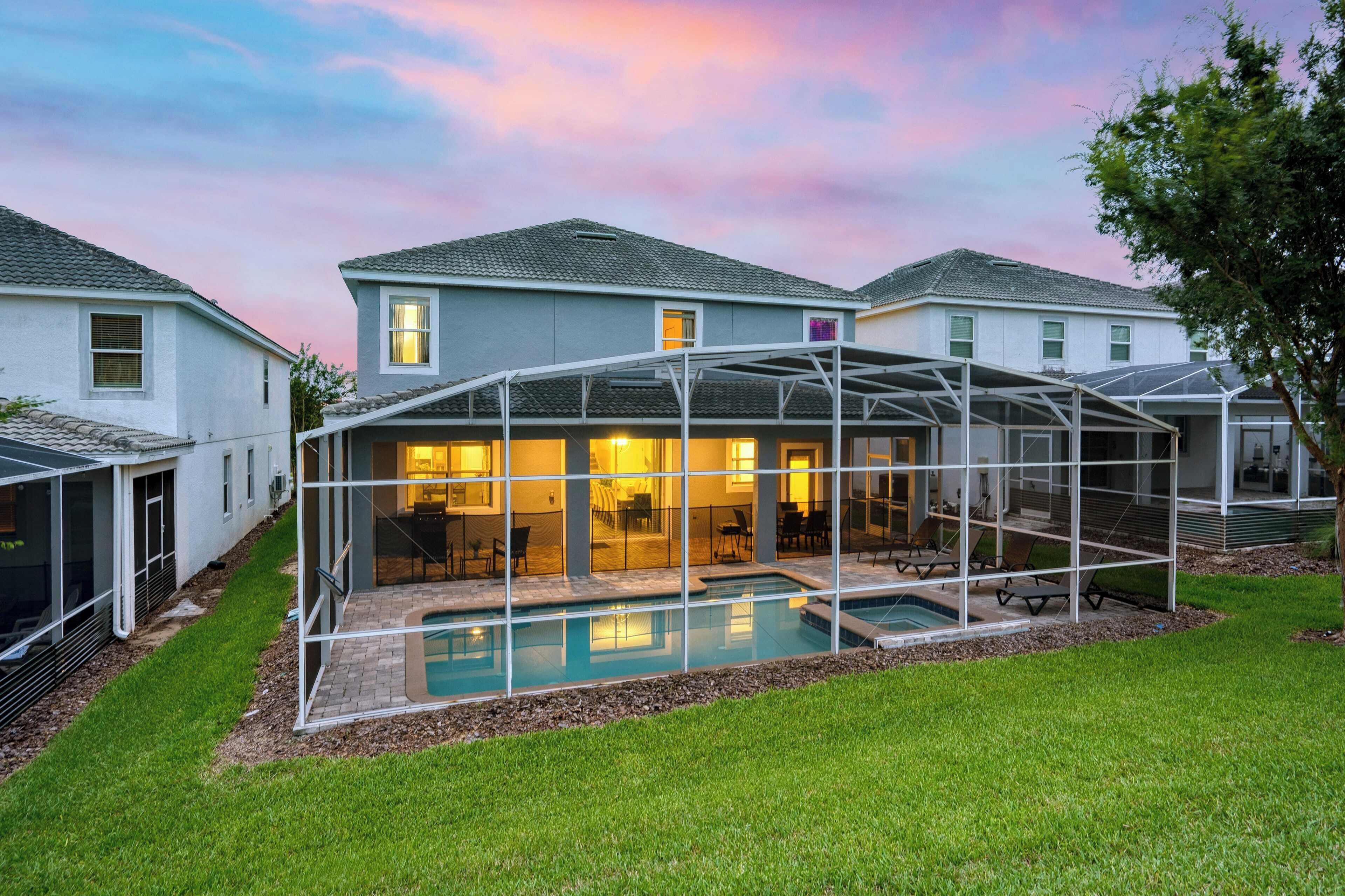 Ein modernes Haus mit einer verglasten Terrasse und einem Swimmingpool.