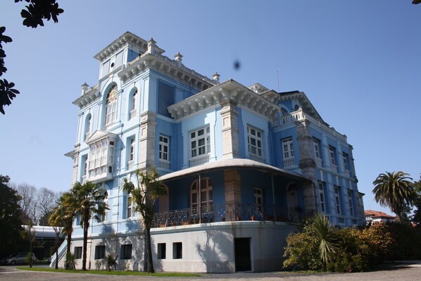 A large, historic building with a prominent central tower and multiple balconies.