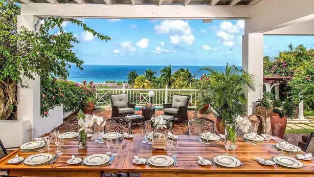 A dining area with a view of the ocean, surrounded by lush greenery and tropical plants. - Beautiful, Well-Appointed Villa With Excellent Staff and Magnificent Sea Views (Montego Bay)