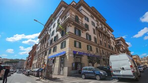 A multi-story building with a central entrance, a sign for 'Centro di Rilancio', and a parked van. - CASA FEN historic building - King of Rome MetroA 2 bedrooms 2 bathrooms (Unknown)