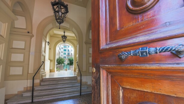 A grand staircase leading to an arched doorway with a wooden door featuring a metal knocker. - CASA FEN historic building - King of Rome MetroA 2 bedrooms 2 bathrooms (Unknown)