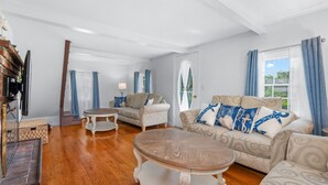 A spacious living room with two sofas, a coffee table, and a television.