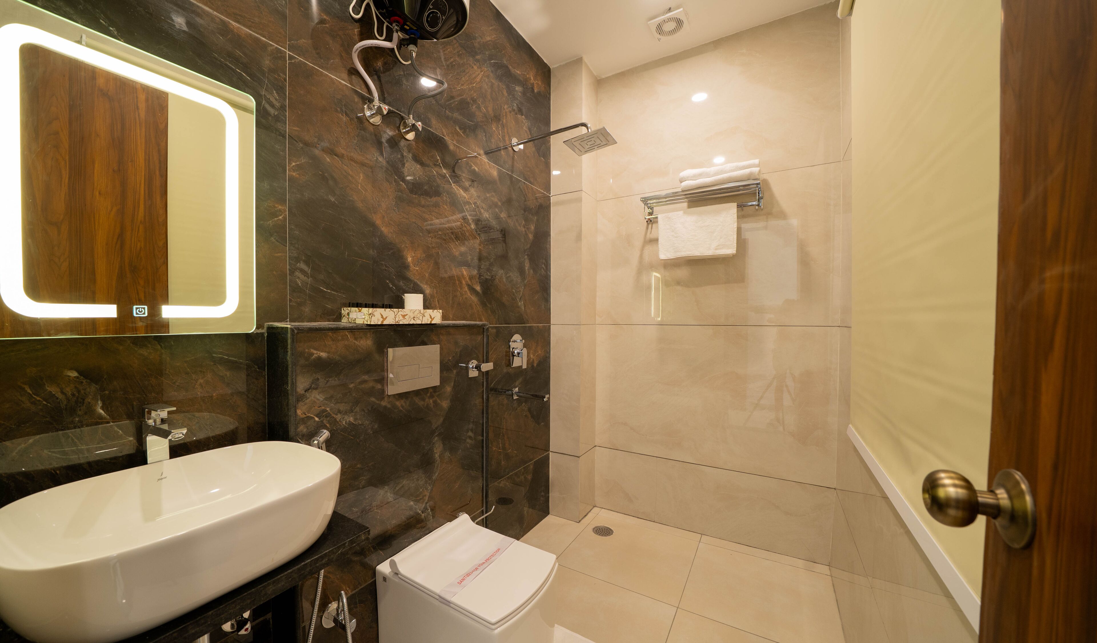 Un baño moderno con un lavamanos grande, espejo, ducha y perchero.