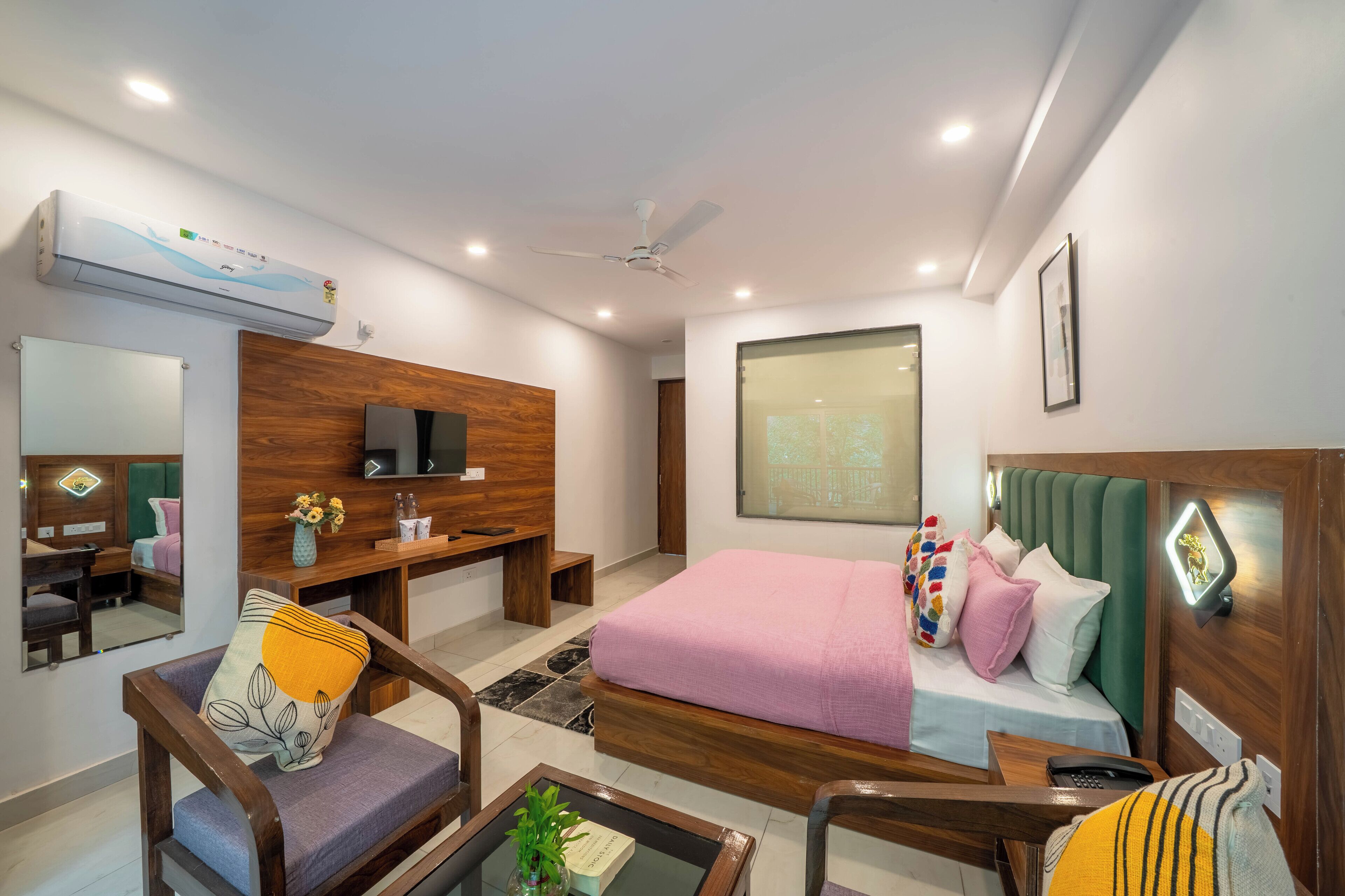 A modern hotel room with a bed, desk, and seating area.