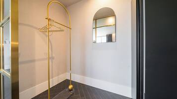 Un baño moderno con un toallero dorado, un espejo y un suelo con diseño oscuro.