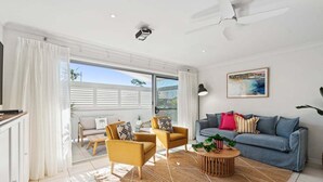 Ein modernes Wohnzimmer mit einer Couch, Sesseln und einem Couchtisch.