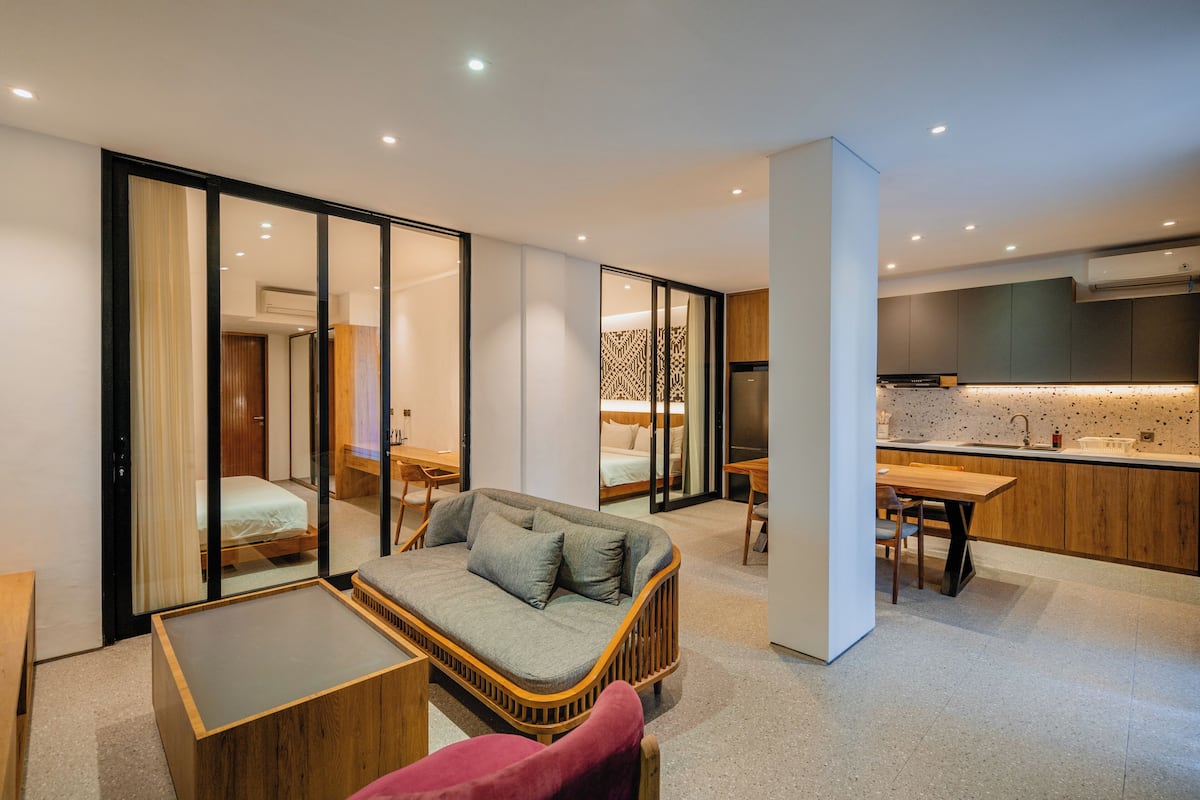 Un interior moderno con un sofá, una mesa de comedor y una zona de cocina.