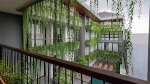 Un edificio de varios niveles con jardines verticales y barandilla de balcón de madera.
