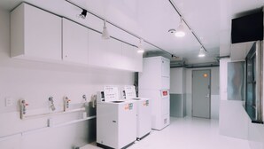 A clean, modern kitchen with white cabinets, stainless steel appliances, and a bright, well-lit environment. - Minimalist Loft 1002 (Osaka)