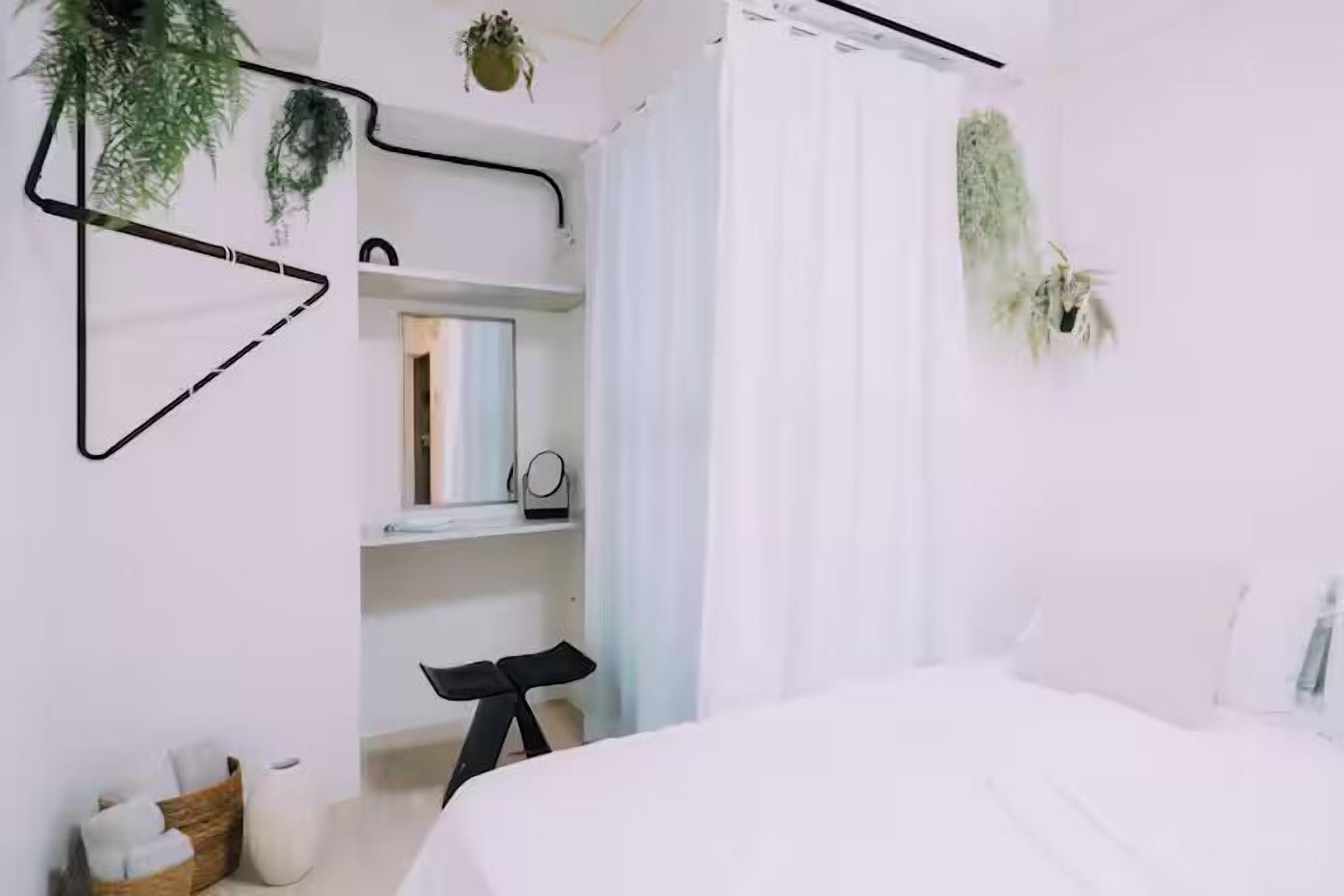 A modern bedroom with a bed, a desk, and shelves.