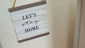 A cozy corner with a sign saying "LET'S stay HOME" and a basket filled with various textured pillows. - Seaside Caravan Goldensands Kinmel Bay-Sleep 6 (Kinmel Bay)
