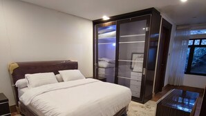 Una camera da letto con un letto grande, un armadio con specchio e un tavolino.