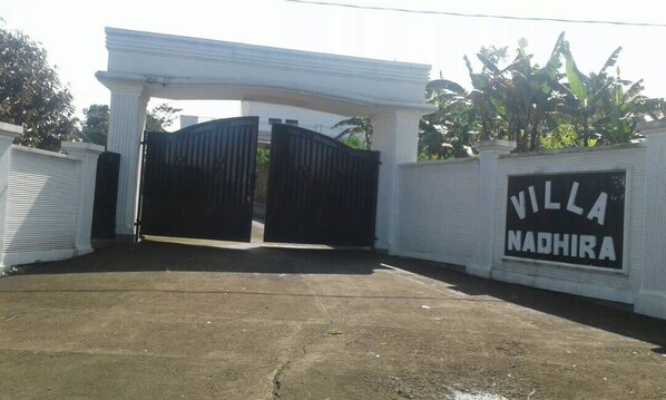A gated entrance with a sign reading "Villa Nadhira".