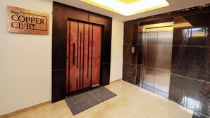 An elevator, a door with a metal handle, and a sign that reads "The Copper Club". - Sathyam Oasis  (Tiruchirappalli)