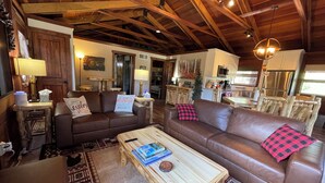 Una sala de estar acogedora con un sofá de cuero marrón, una mesa de centro de madera y una chimenea.