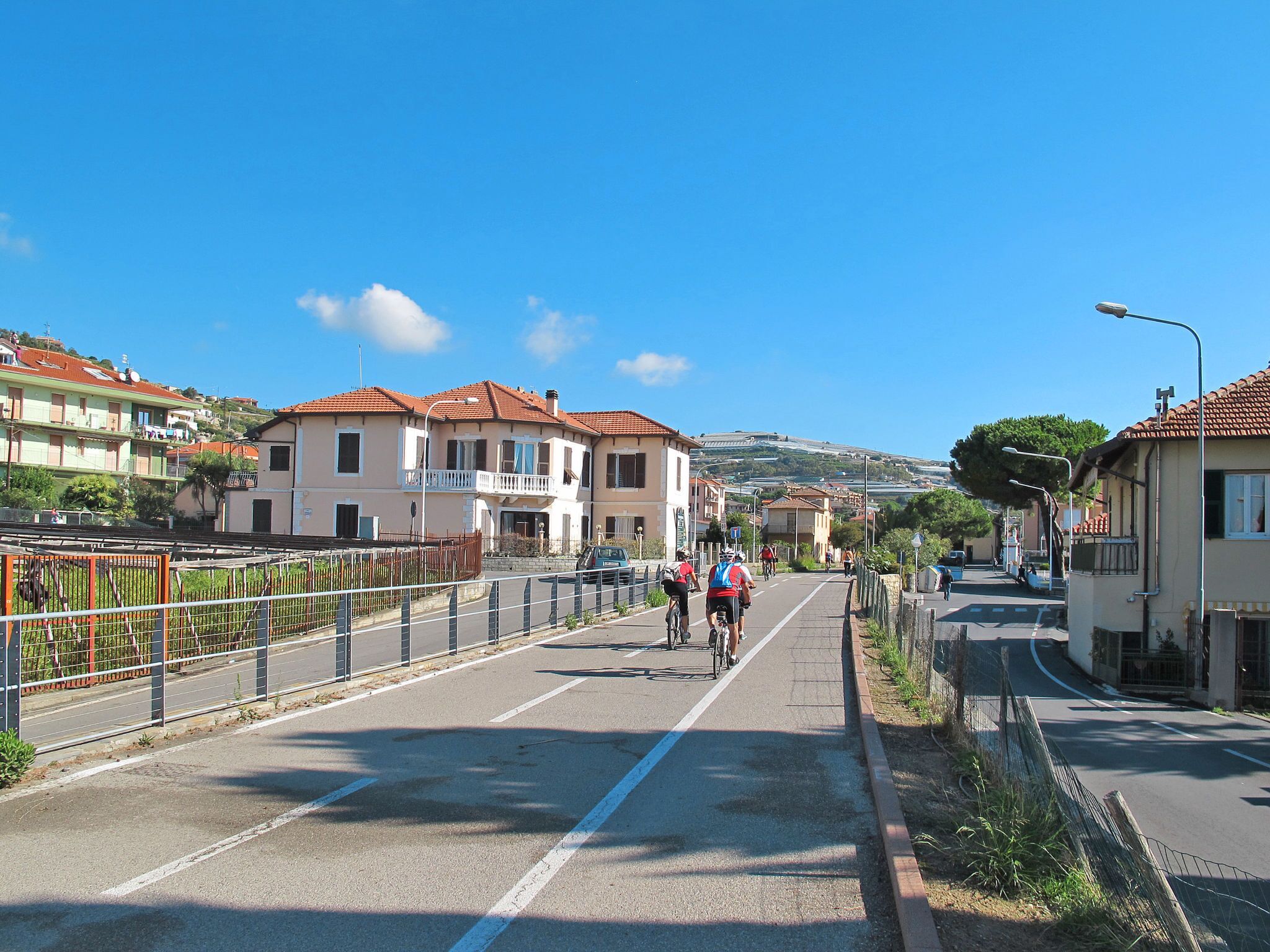 Una calle con casas, un carril bici y una senda peatonal.
