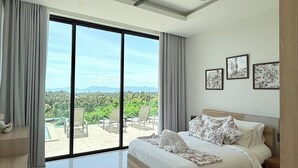 A spacious bedroom with a large bed, a ceiling fan, and a view of a lush landscape through floor-to-ceiling windows. - Michel Tropical Seaview Pool Villas  (Mae Nam)