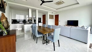 A modern living room with a dining area, a kitchen, and a TV. - Michel Tropical Seaview Pool Villas  (Mae Nam)