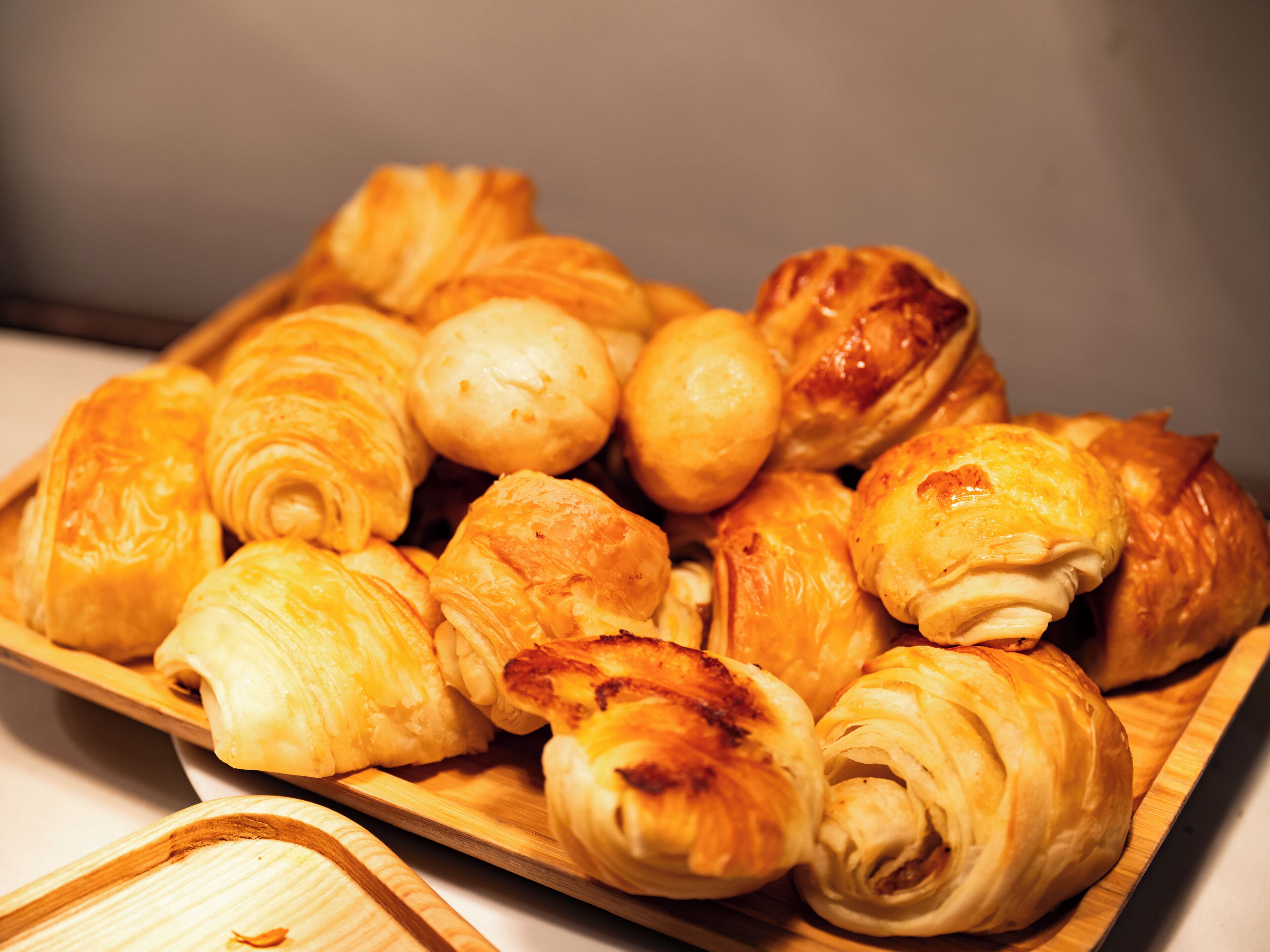 A tray of assorted pastries including croissants and puff pastries.