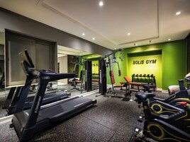 A modern gym with treadmills, weight machines, and a mirrored wall.