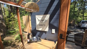 Ein Holztisch und Stühle in einem Raum, mit einem Schild mit der Aufschrift 'Saltwater + Sunsets'.