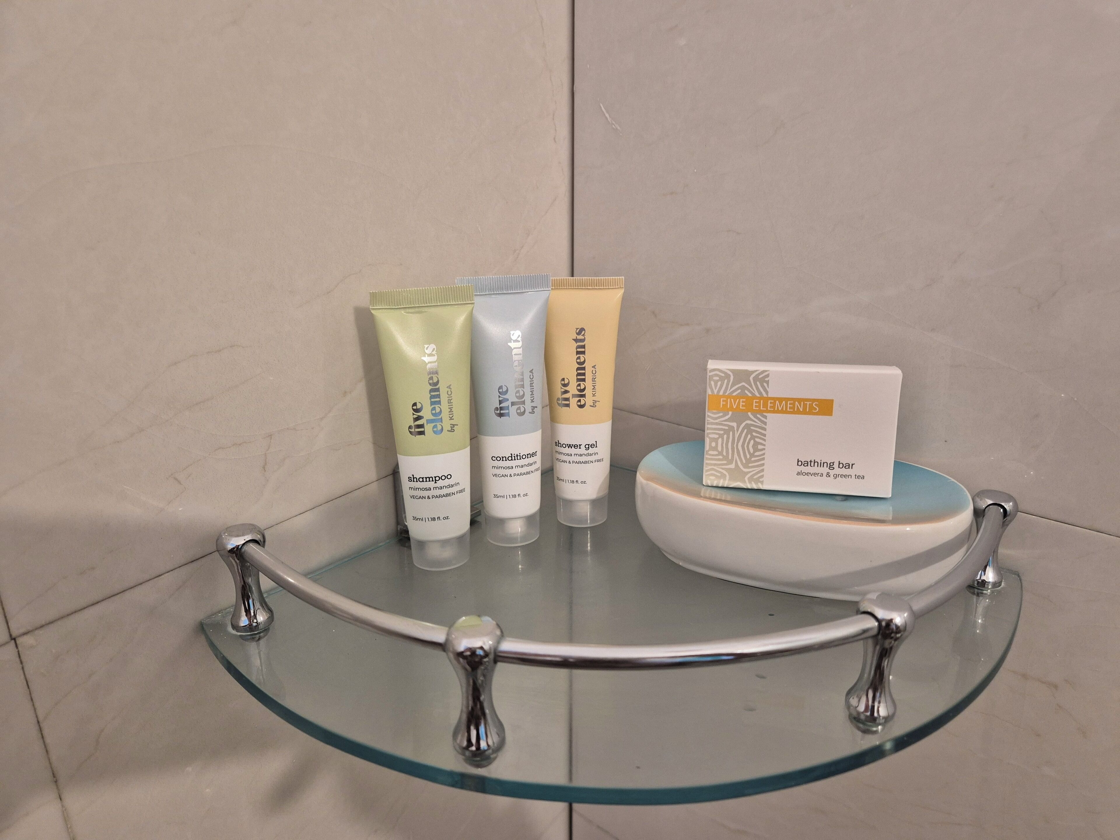 Estante de baño con artículos de aseo, incluyendo champú, acondicionador, gel de ducha y jabón de baño.