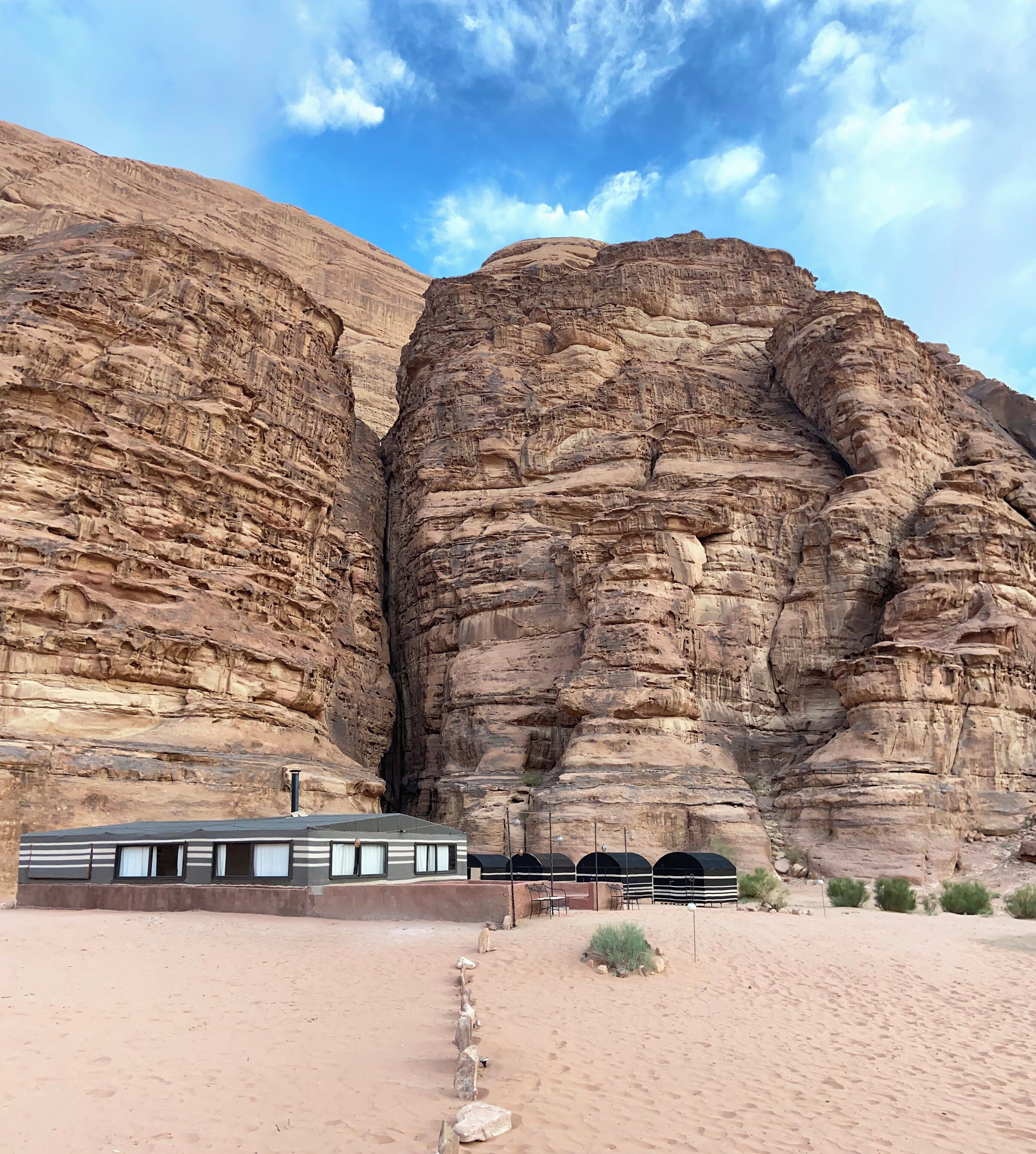A desert hotel with a large rock formation in the background.