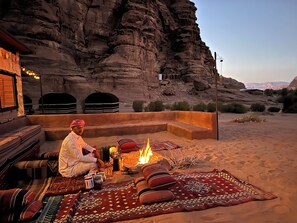 A desert setting with a traditional tent and a fire pit. - Desert Camp and Retreat Center with Staff and a Cook in Wadi Rum, Jordan (Gouvernement Aqaba)