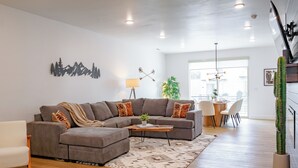 A modern living room with a sectional sofa, a coffee table, and a cactus plant. - Luxury Townhome (Park City)