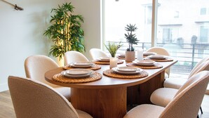 A dining table set with plates, a candle, and a potted plant. - Luxury Townhome (Park City)