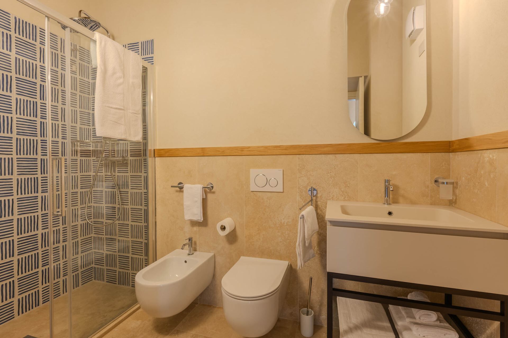 Ein Badezimmer mit Bidet, Toilette, Waschbecken und Spiegel.