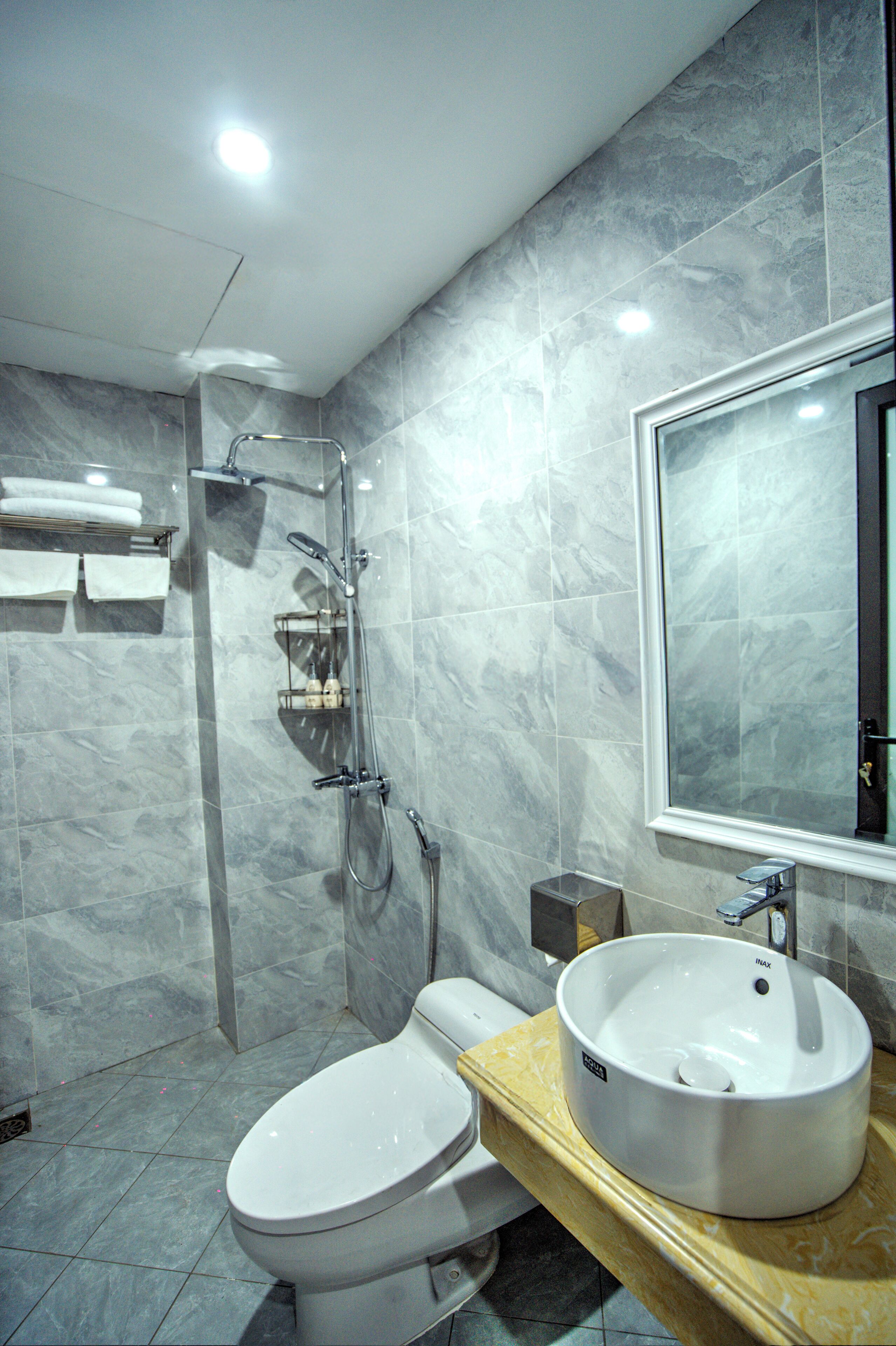 Ein modernes Badezimmer mit Toilette, Waschbecken und Dusche.