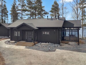 A modern two-story house with a dark exterior, a front porch, and a glass door leading to a covered outdoor area. - Tervaranta by Interhome (Ähtäri)