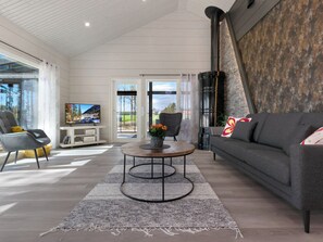 A modern living room with a sofa, a coffee table, and a television. - Tervaranta by Interhome (Ähtäri)