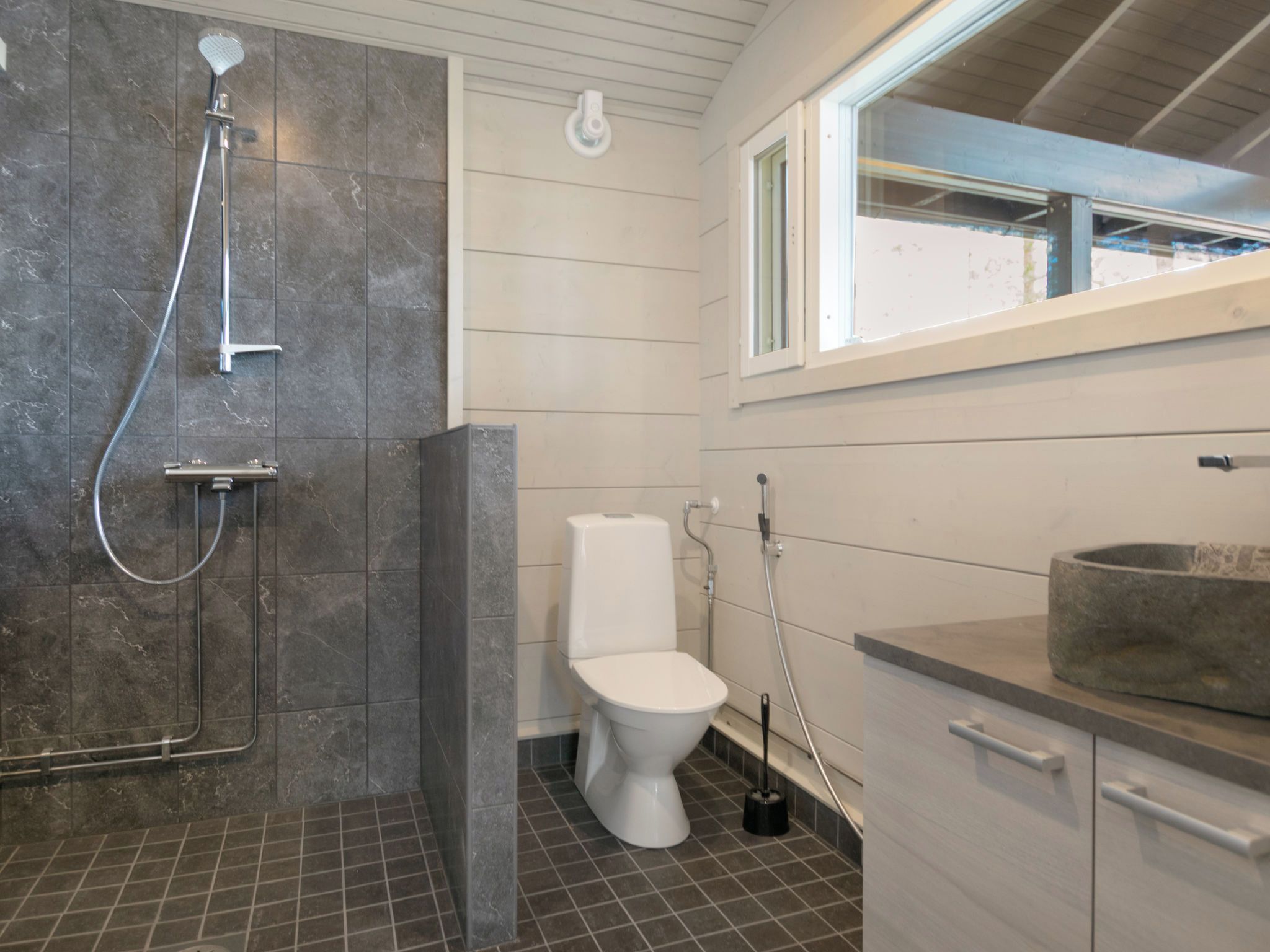 Ein Badezimmer mit Dusche, Toilette und Waschbecken.