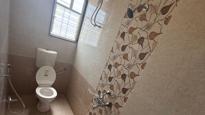 A bathroom with a toilet, a shower, and a sink. - Hotel Wow Inn  (Pune)
