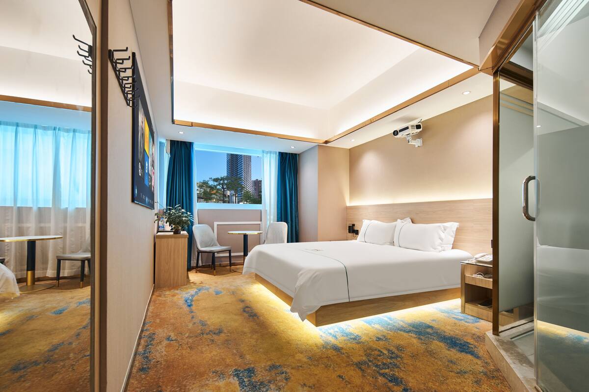 Quarto de hotel moderno com uma cama grande, uma escrivaninha e uma cadeira.