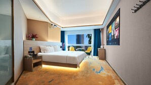 A modern hotel room with a large bed, a desk with a lamp, a view of the city, and a wall-mounted TV. - Meiyi Grand Hotel Shenzhen Huanggangcun (Shenzhen)