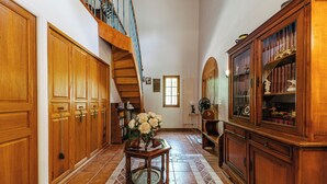 A spacious hallway with wooden cabinets, a staircase, and a large wooden cabinet with glass doors. - Villa Hokiss - Private pool on 1 ha of nature (Le Muy)
