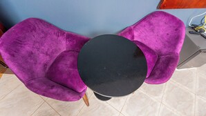 Una habitació amb una cadira morada i un taulell negre.