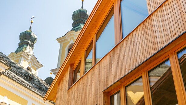 A building with wooden facade and large windows, featuring a traditional architectural style with domed roofs.