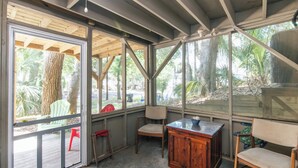 Una habitación con ventanas amplias, vigas de madera y vistas a palmeras.