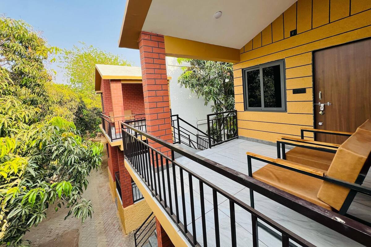 A modern building with a balcony, a wooden door, and a window.